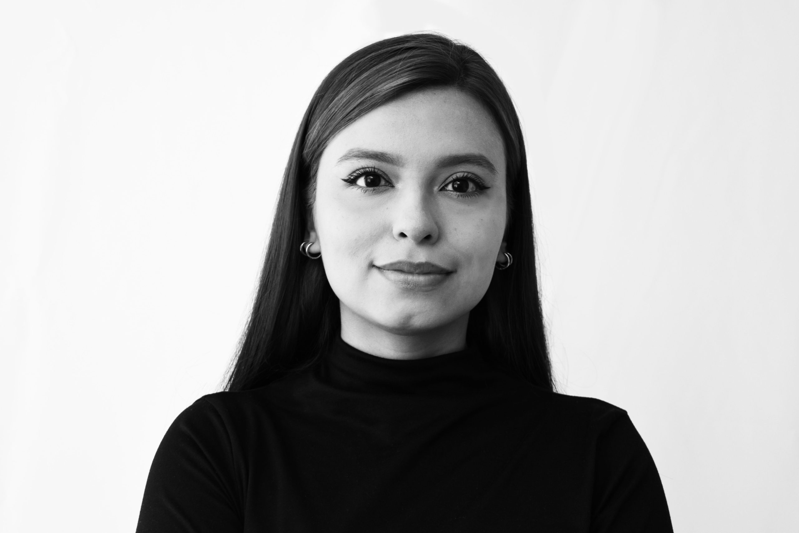 Elegant black and white portrait of a confident young woman with long hair and earrings.